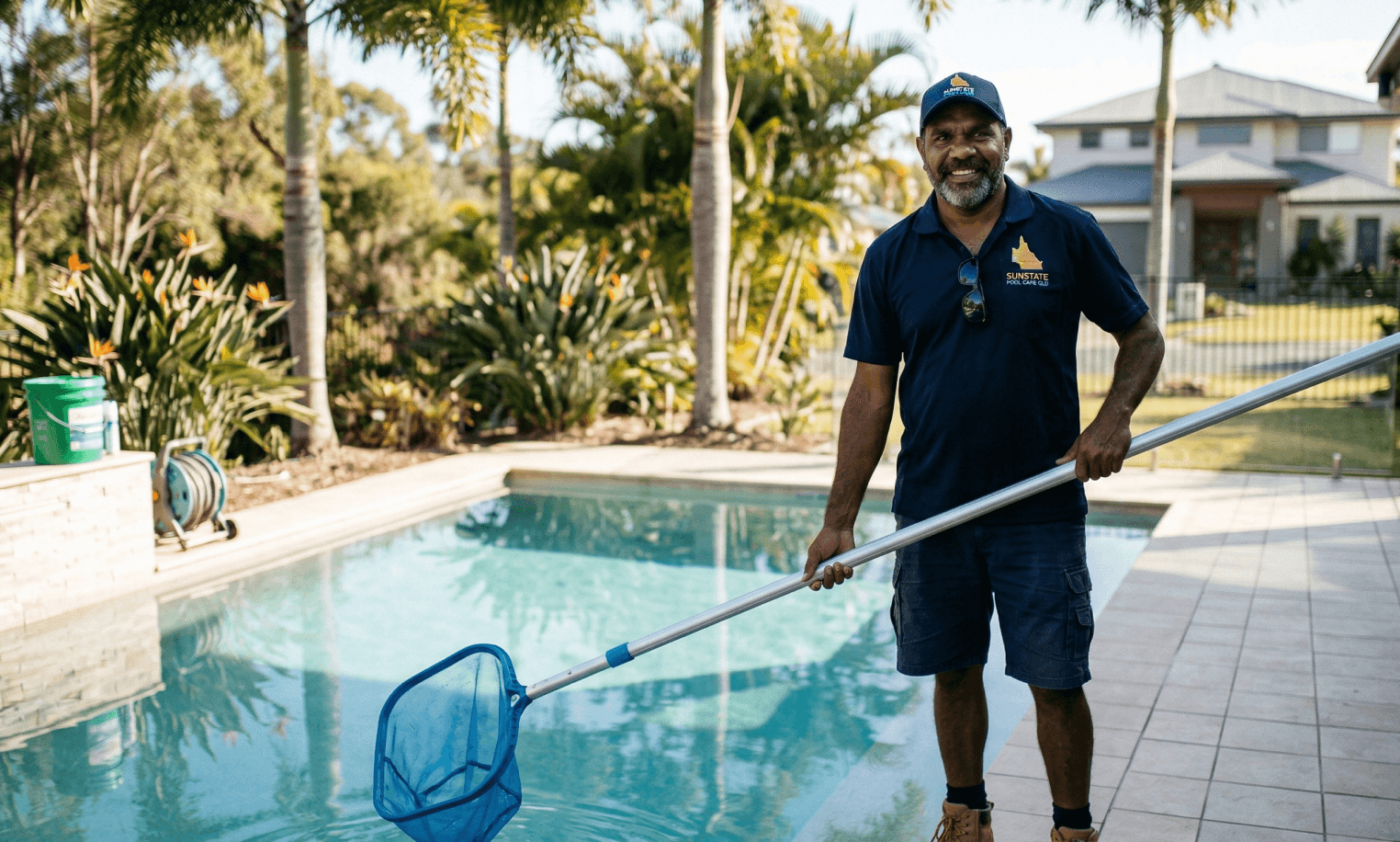 Pool service professional standing beside a pool